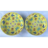 A pair of Chinese yellow ground dishes decorated in polychrome with butterflies to the interior