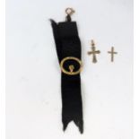 A gold mounted watch/mourning ribbon with 9ct mountigs; a 9ct gold crucifix and an 18ct gold