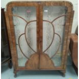 A 1930's walnut china cabinet enclosed by 2 doors