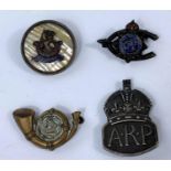 A hallmarked silver ARP badge, a wishbone badge, a mother of pearl backed badge with central crest