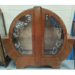An Art Deco style circular walnut display cabinet enclosed by 2 doors with mirrored decoration