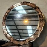 A circular peach framed wall mirror.