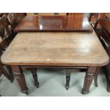A Victorian mahogany wind out dining table with one spare leaf, on reeded legs and castors