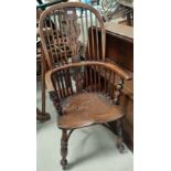 A 19th century elm Windsor armchair with high back and crinoline stretcher, on turned legs