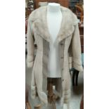 A modern full length pale mink coat with beige leather trim