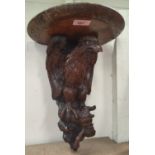 A Black Forest style carved oak wall bracket in the form of an eagle, height 37cm.