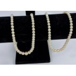 Two graduating pearl necklaces with white metal clasps