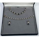 A silver gilt suite comprising necklace, bracelet and earrings, set dark blue and clear stones,