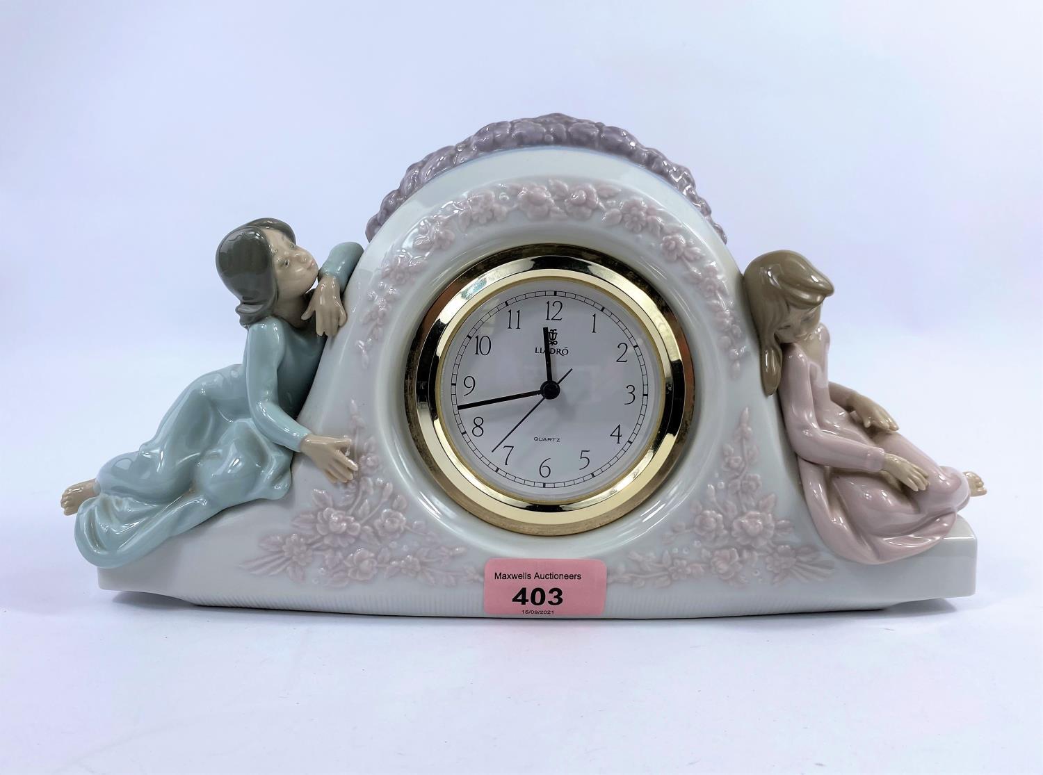 A Lladro porcelain clock, numbered 5776, with quartz movement & two young girls sat either side,