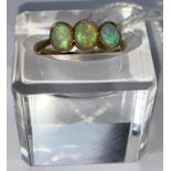 A yellow metal ring set 3 opals, stamped '18ct', 2.6 gm