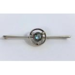 A white and yellow metal bar brooch set central light blue stone surrounded by 3 old cut diamonds,