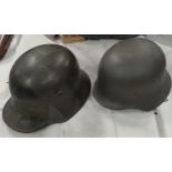 A German style steel helmet with a leather lining and a similar reproduction helmet.