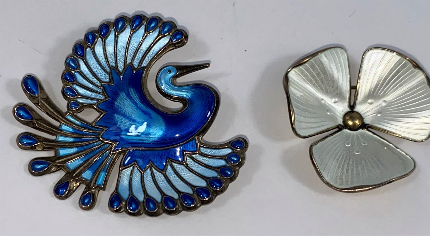 A Norwegian blue enamelled sterling brooch of a mythical bird by David Andersen; a similar floral