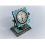 An Art Deco style green enamel on silver, swivel mounted dressing table/desk clock on a