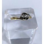 a 3 stone diamond dress ring in crossover setting stamped 18ct and Pl, 1.9gm size N