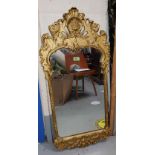 An ornate gilt metal framed wall mirror with shell decoration full height 99cm