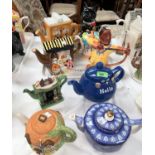 10 Novelty teapots including black cat, merry-go-round, stall, writing bureau etc