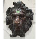 A cast bronze garden wall decoration in the form of a lion's mask, steel suspension bar, 46cm