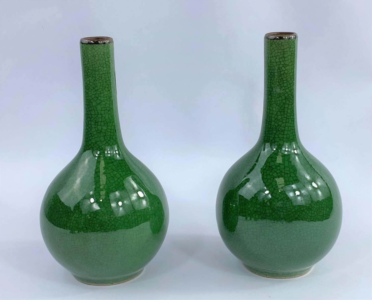 A pair of Chinese monochrome green crackle glaze bottle vases, with slender necks and bulbous