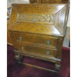 A 1930's oak bureau with pull out fitted interior writing desk, leather inset, calendar letter