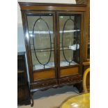 An Edwardian Sheraton style side/display cabinet in inlaid crossbanded mahogany with 2 doors and 2