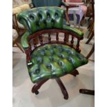 A deeply buttoned back green leather effect swivel offiec chair with bow back and rise and fall