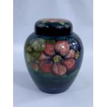 A MOORCROFT ginger jar decorated with flowers on blue/green ground, 20cm