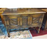 A Jacobean style side cabinet, enclosed by two carved doors.