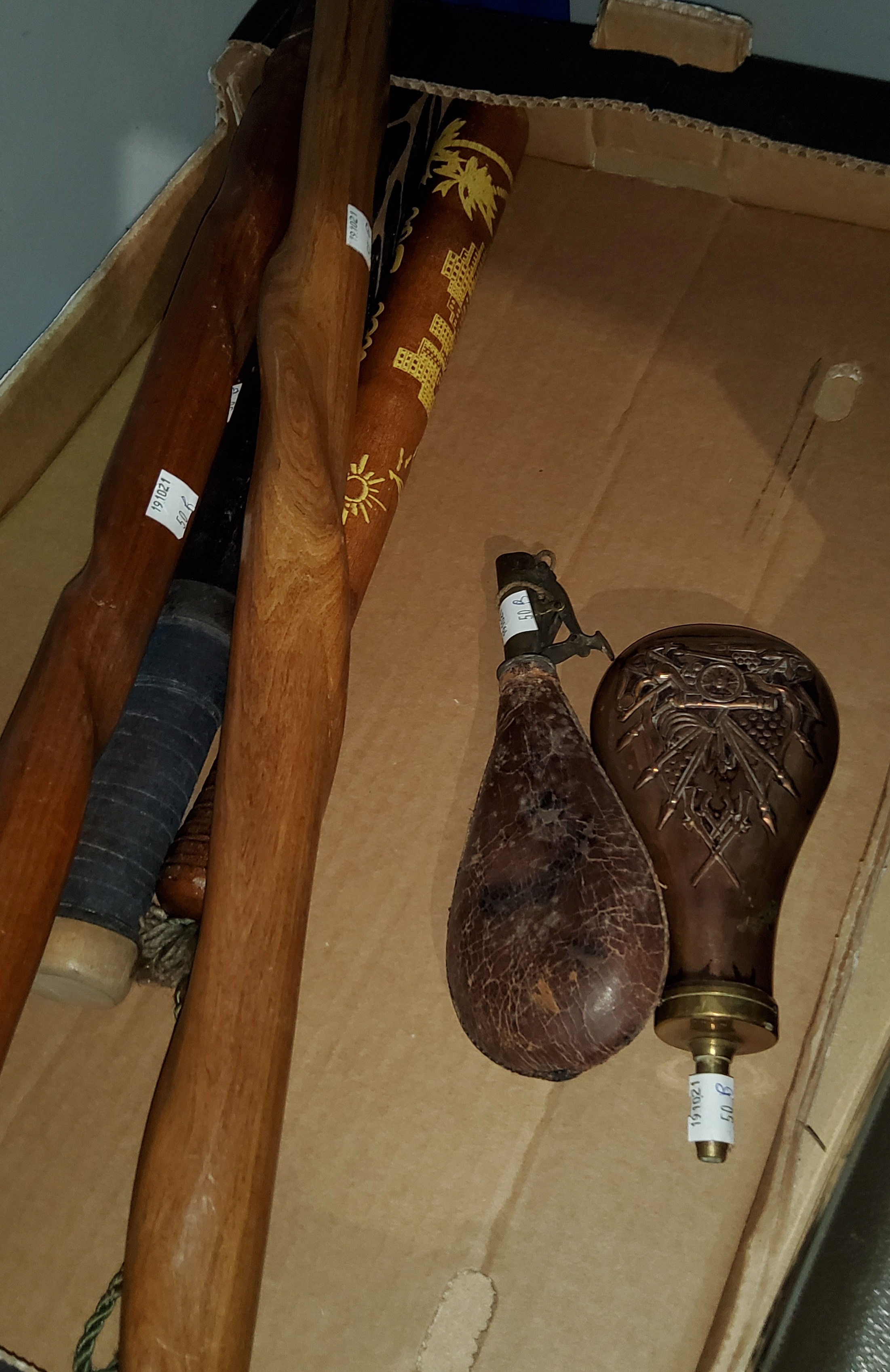 An American copper and brass powder flask and another leather and brass, Two African walking