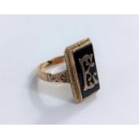 A gold metal ring set with a rectangular black stone and monogram "E" stamped 9ct gold. 5gms. size P