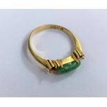 A yellow metal ring stamped "835" set with an elongated green stone, 2.5gms (tests as circa 18ct)