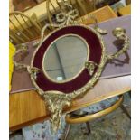 An oval wall mirror in gilt frame with ornate sconces