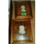 A relief carved pair of head and shoulder silhouettes on walnut plaques