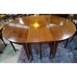 A large mahogany dining table comprising two demi lune ends with central drop leaf section