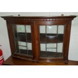 An oak wall hanging two door display cabinet with leaded glass doors with idividial convex panels (