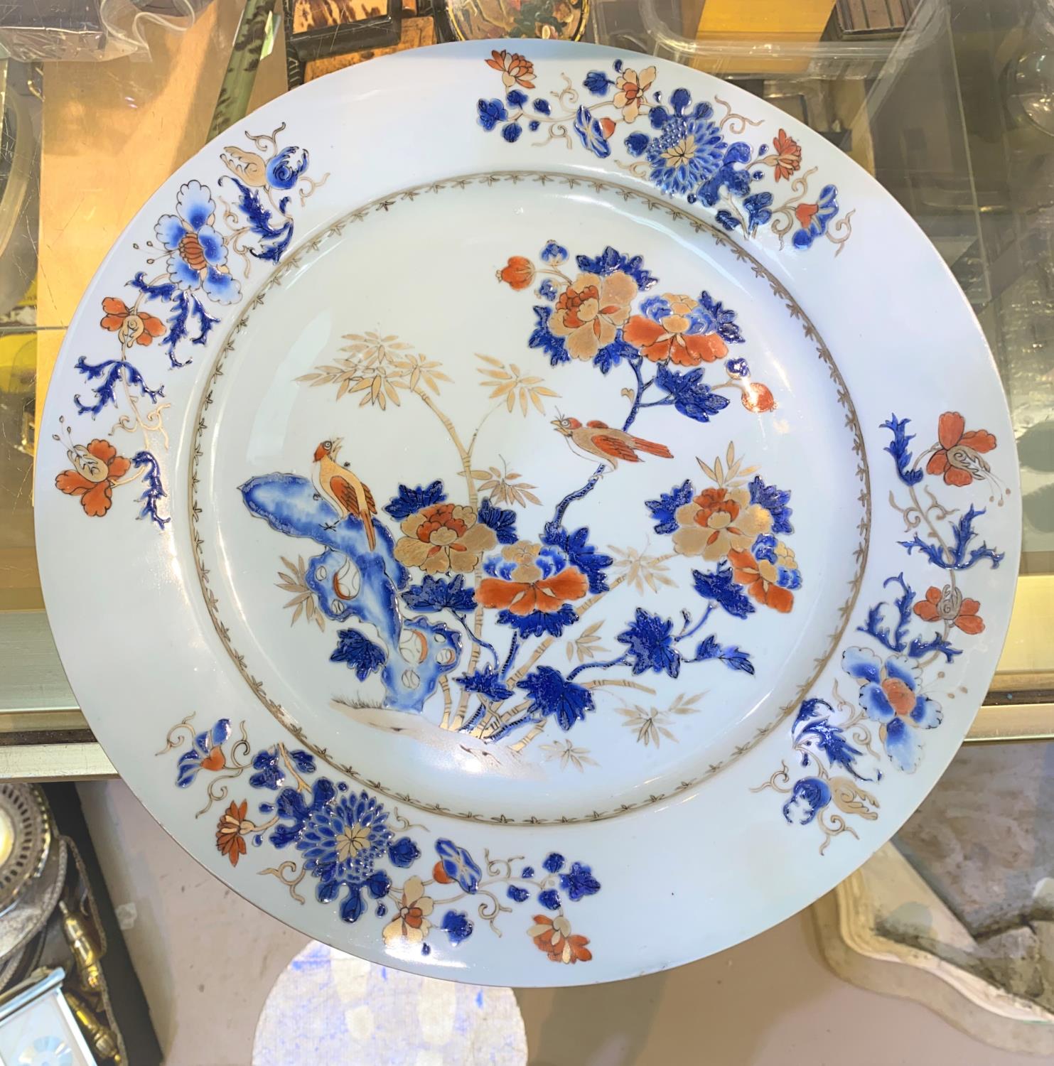 A large Chinese porcelain charger with central panel depicting birds on trees with gilt highlight,