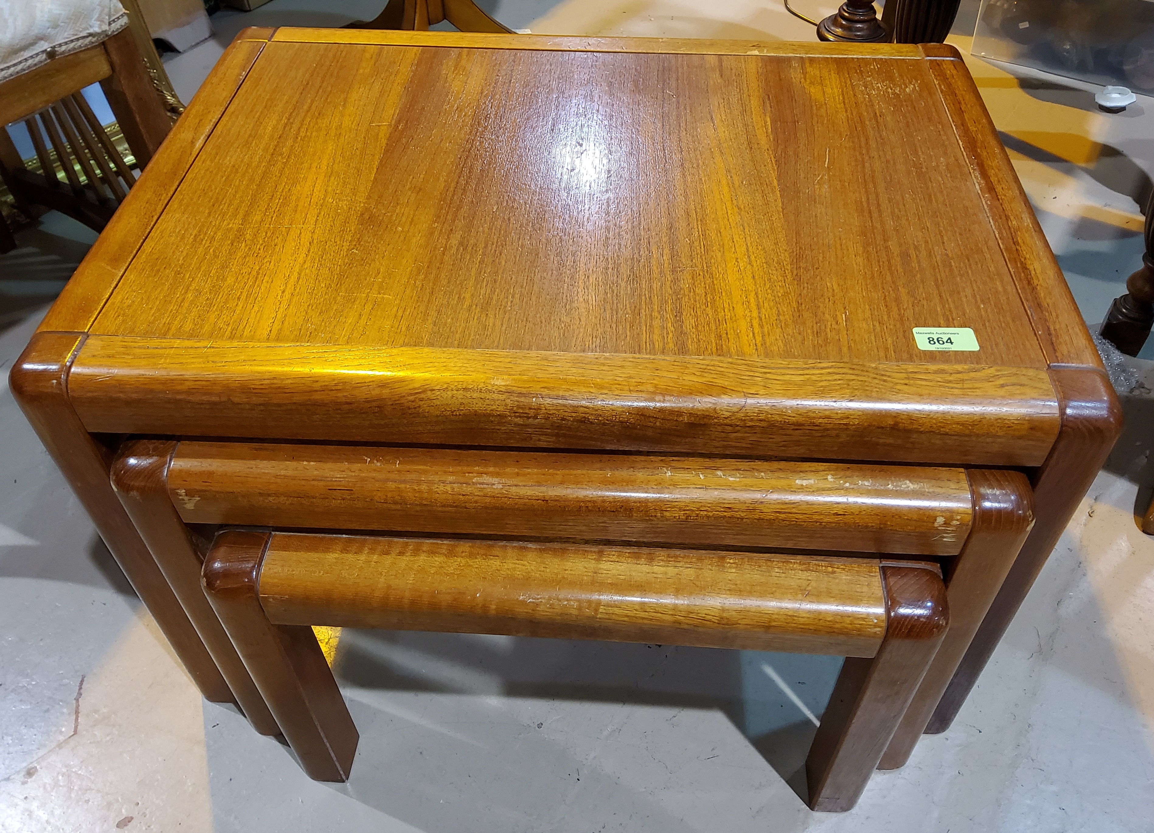 A mid 20th century teak nest of three tables with rounded corners, largest length 69cm