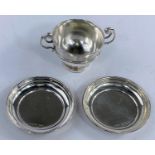 A pair of hallmarked silver taster dishes and a small hallmarked silver two handled cup, 2.3oz