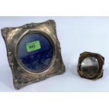 A silver square photo frame with embossed border and circular aperture, Birmingham 1905; a folding