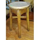 An oak Arts and Crafts style circular stool with champhered legs and X-frame support