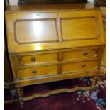 An oak bureau with panelled fall front and two drawers with barley twist legs width 90cm, height