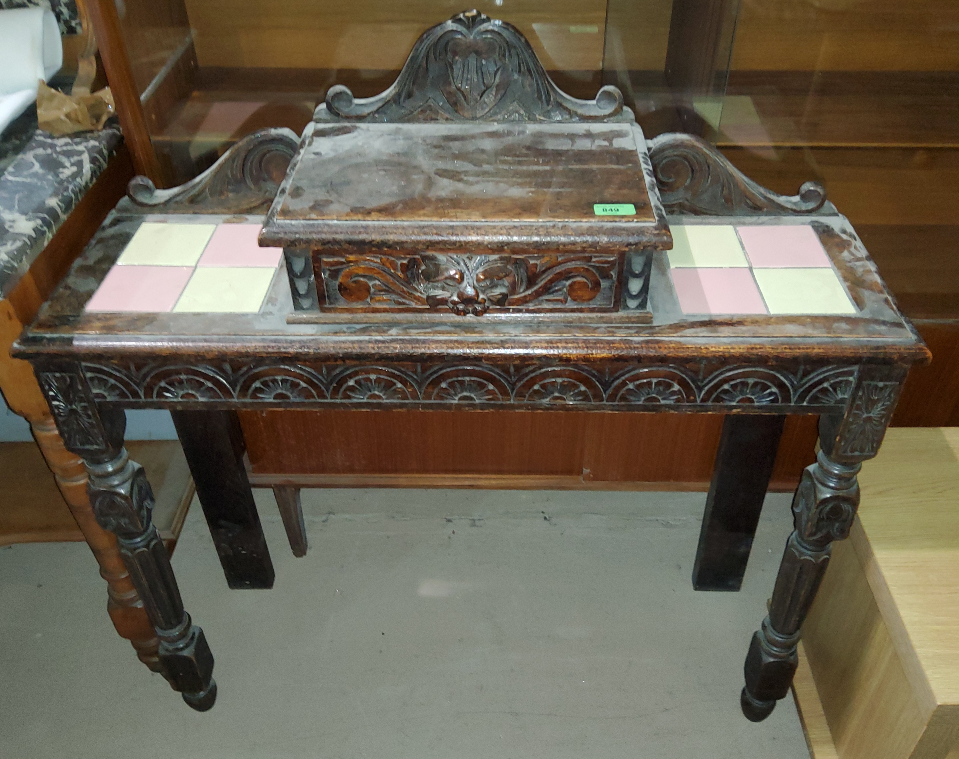 A carved oak side table with single drawer to the top, with inset tiles, on tapering front legs