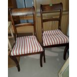 A Regency set of 5 mahogany dining chairs with sabre legs, regency stripe seats