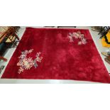 A Chinese red ground carpet with floral decoration, 412 x 310cm