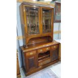 An Edwardian walnut full height sideboard with carved decoration, twin glazed doors over 3