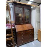 A Georgian bureau bookcase with glazed double doors to the top with arched decoration, four