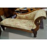 A Victorian walnut chaise longue with scrolled griffin carved back and floral cushions