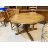 An Ercol medium oak dining suite comprising single pedestal table with circular extending top and