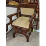 A late Victorian carved oak 'X' framed armchair in cream dralon