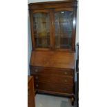 A 1930's oak bureau bookcase with leaded glass, double doors and three drawers below, height